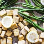tofu and asparagus on a sheet pan with slice lemons