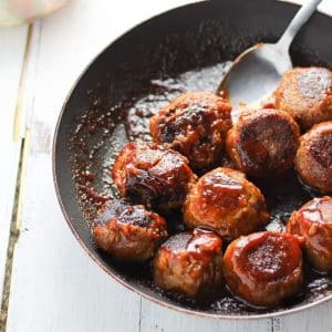bbq lentil meatballs in a skillet with a spoon