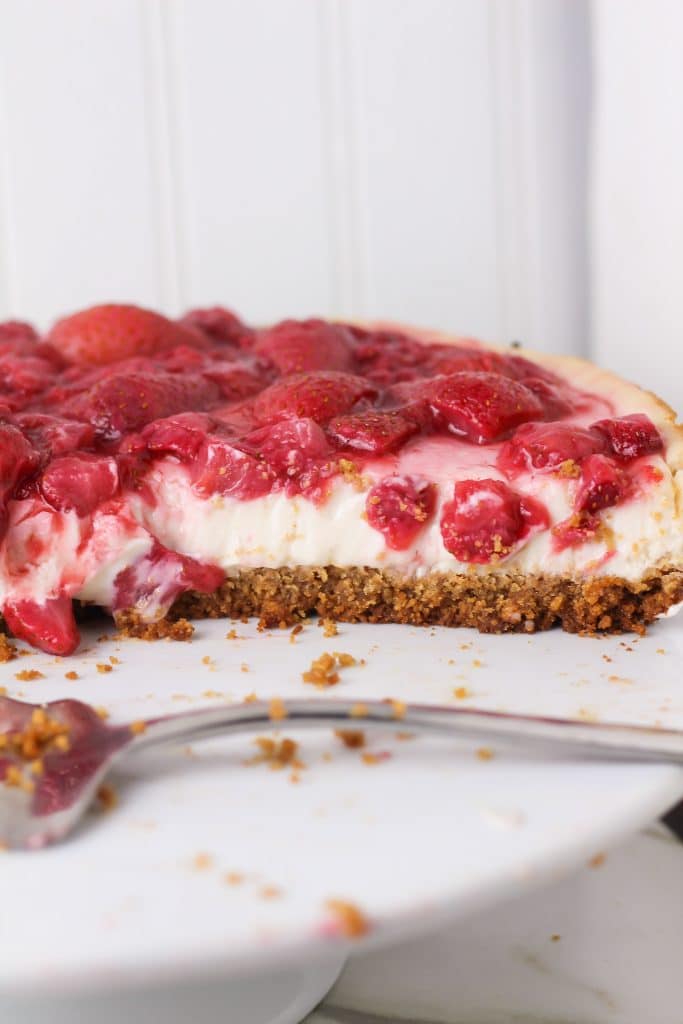  strawberry vegan cheesecake pie sliced from pie showing at a side angle 