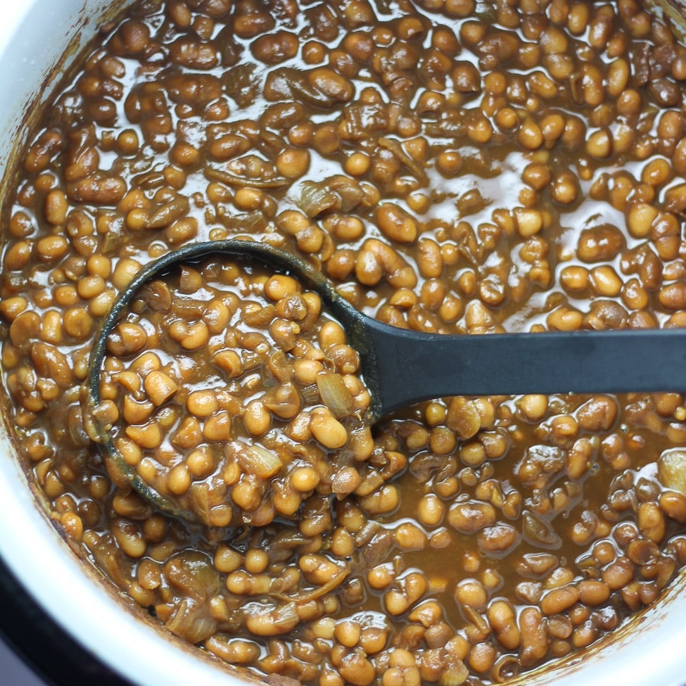 baked beans in a Ninja Foodi with a ladle scoping up beans