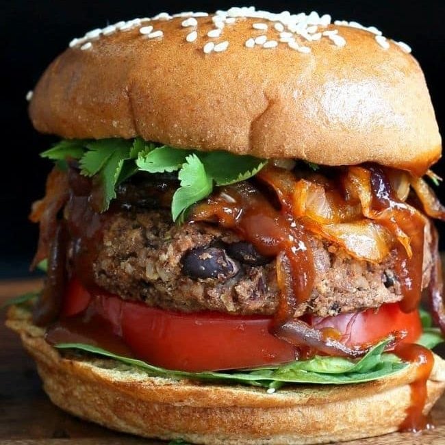 black bean burger topped with caramelized onions, bbq sauce, lettuce on a bun