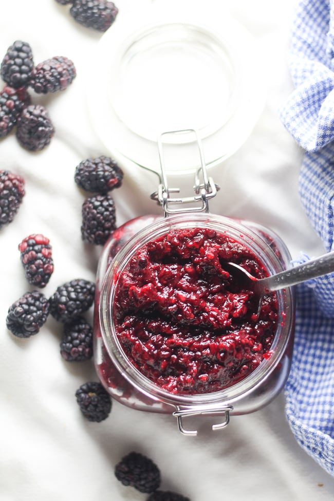 blackberry jam in glass jar with spoon in it