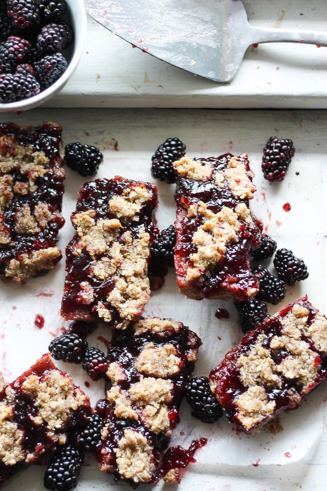 blackberry bars on parchment paper with fresh blackberries