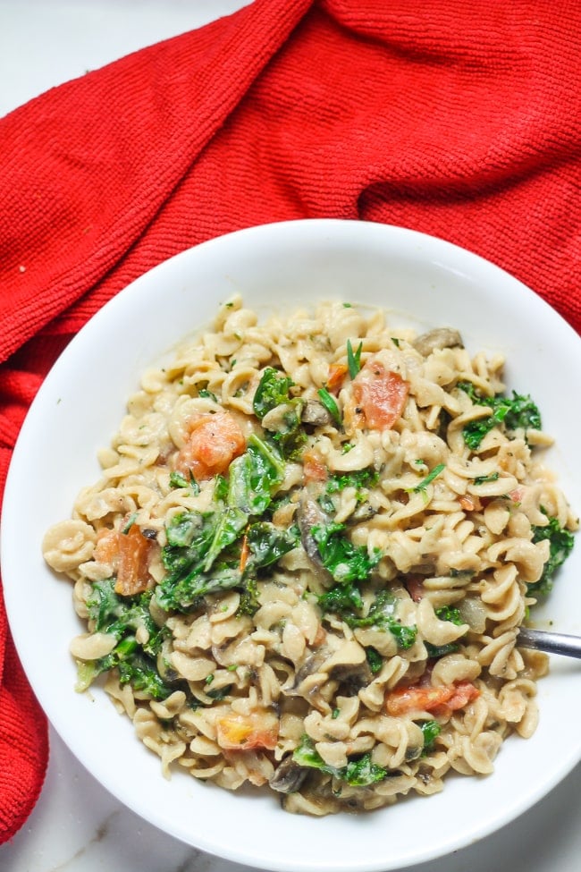 creamy pasta in a white bowl with fork in it