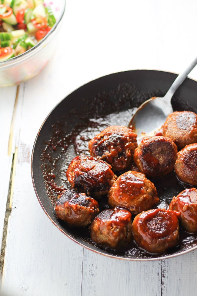 bbq lentil meatballs in a skillet with a spoon