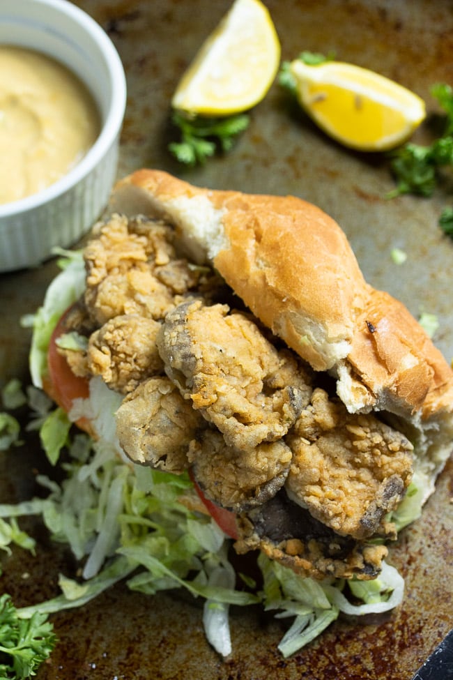 fried oyster mushrooms sandwich with french bread topped with lettuce and tomatoes