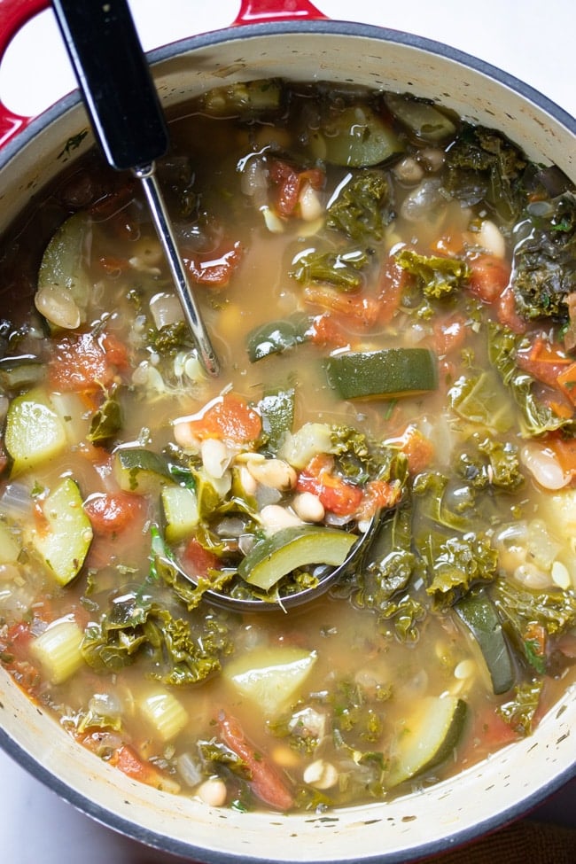photo of vegetable soup in a pot with a ladle