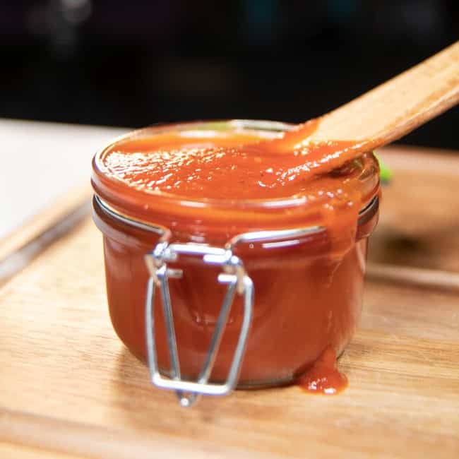 BBQ sauce in a jar with a wooden spoon in it