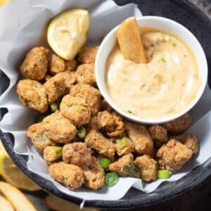 fried okra in a black bowl with fries and remoulade sauce