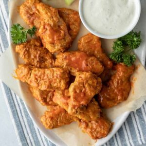 vegan buffalo wings on a party plate with dipping sauce