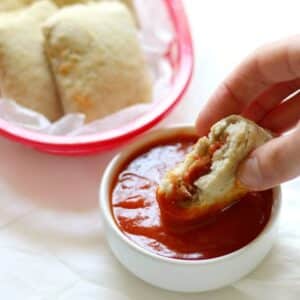 pizza rolls being dipped in marina sauce