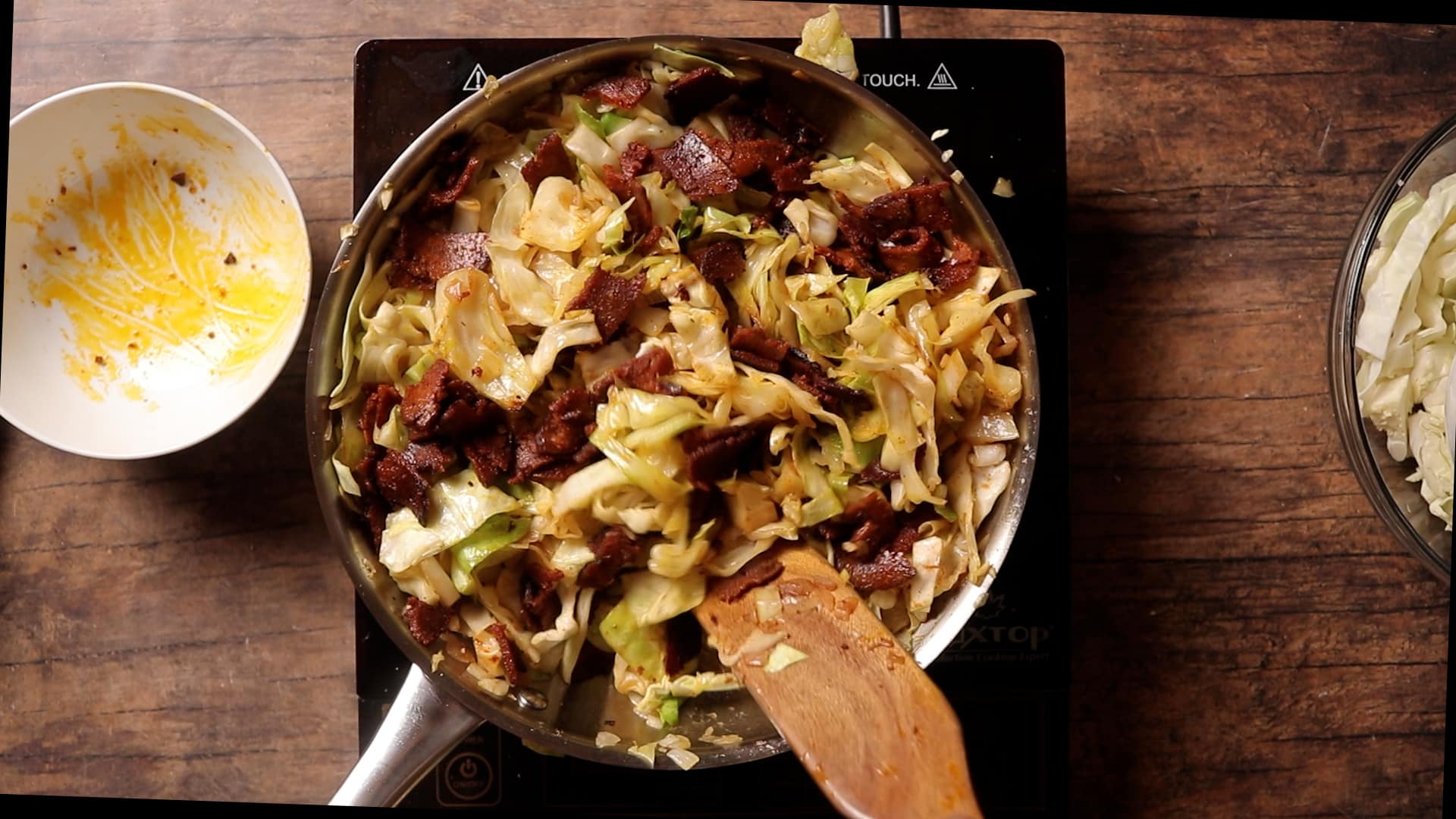 photo of step 8 of vegan bacon being added to finished fried cabbage