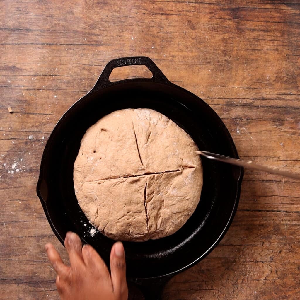 dough being scored inside a cast iron skillet