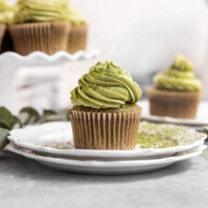cupcake with green frosting sitting on a plate