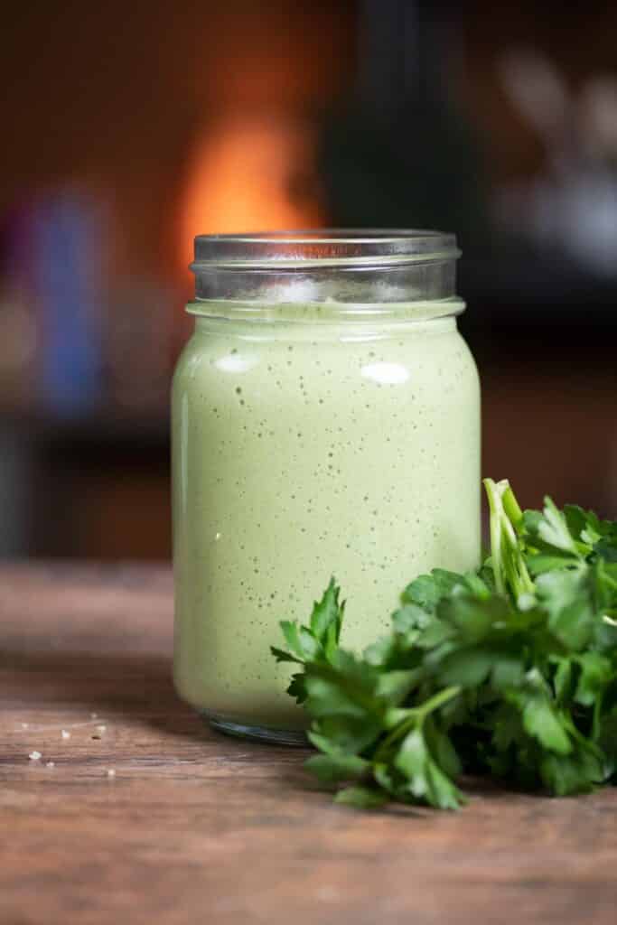 Parsley smoothie in a jar on a table top