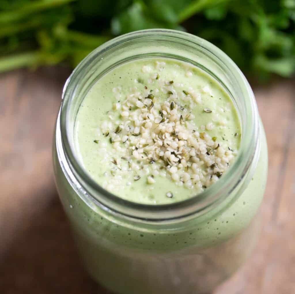 top angle of parsley smoothie in a jar sprinkled with hemp seeds
