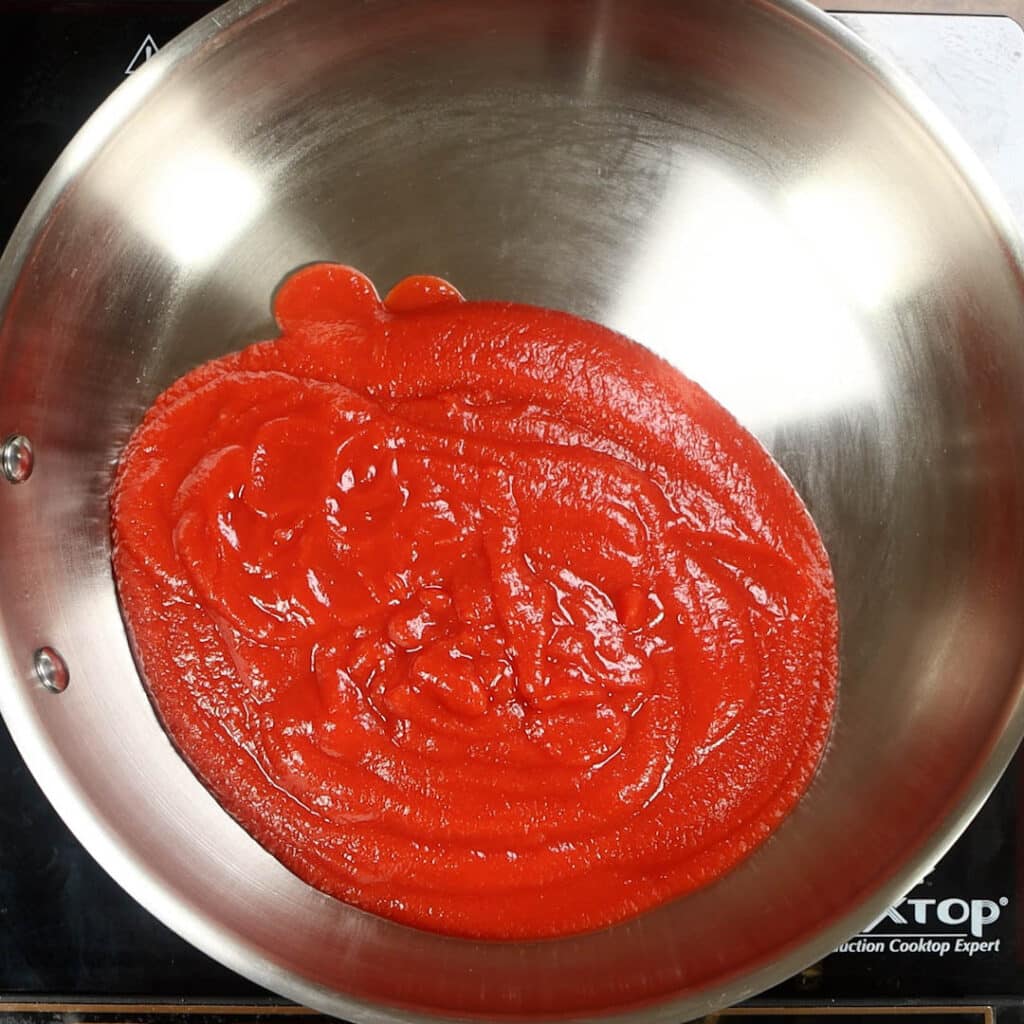 showing step 1 of tomato puree in a skillet