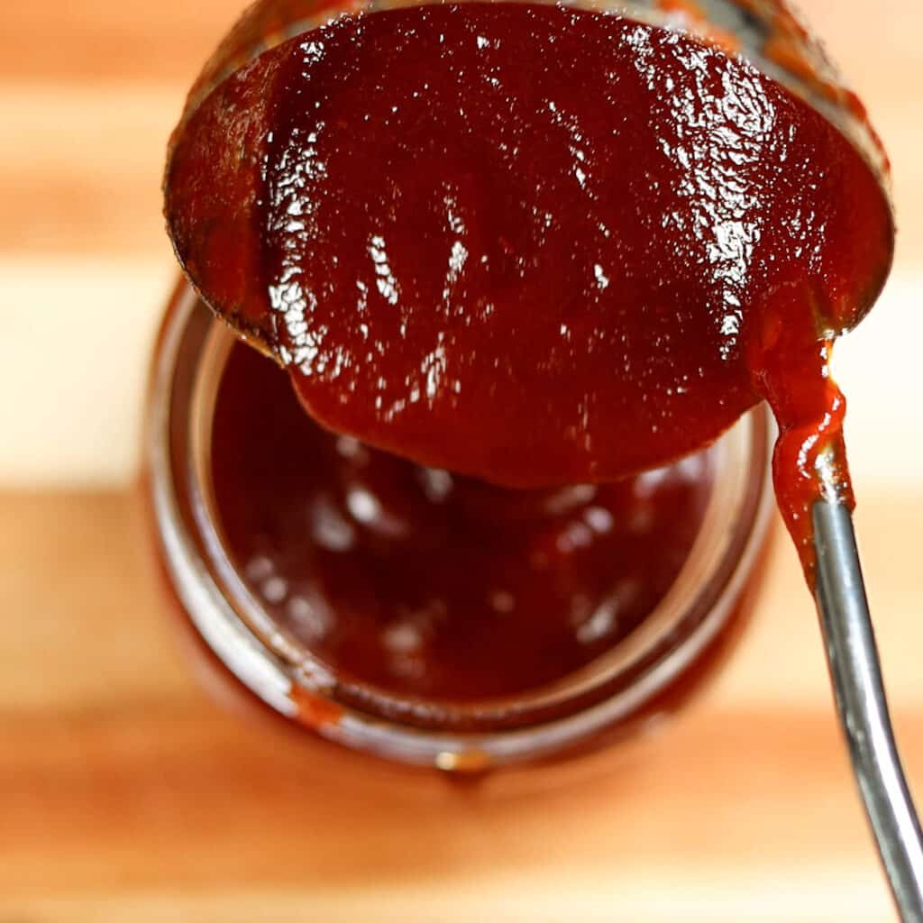 step 5 showing bbq sauce being added into a jar