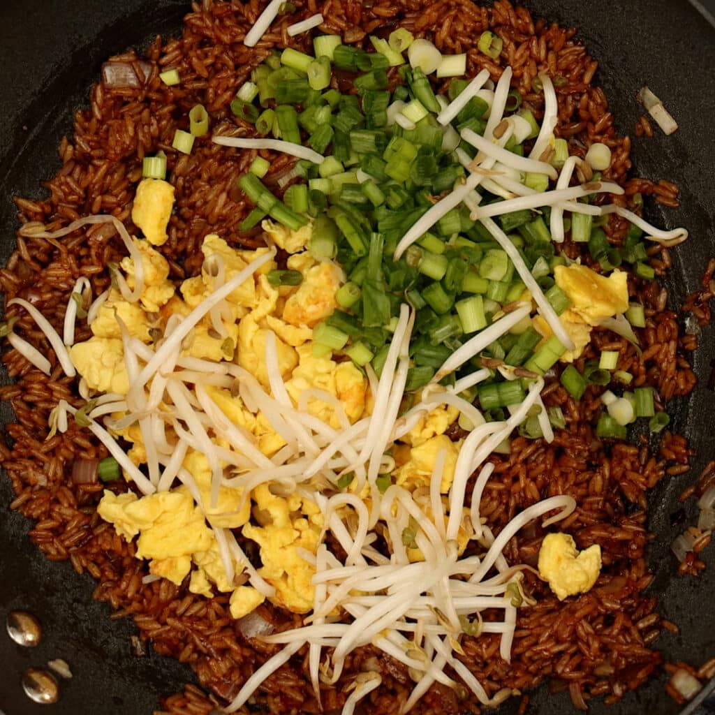 vegan egg, green onions, and bean sprouts with rice in a wok