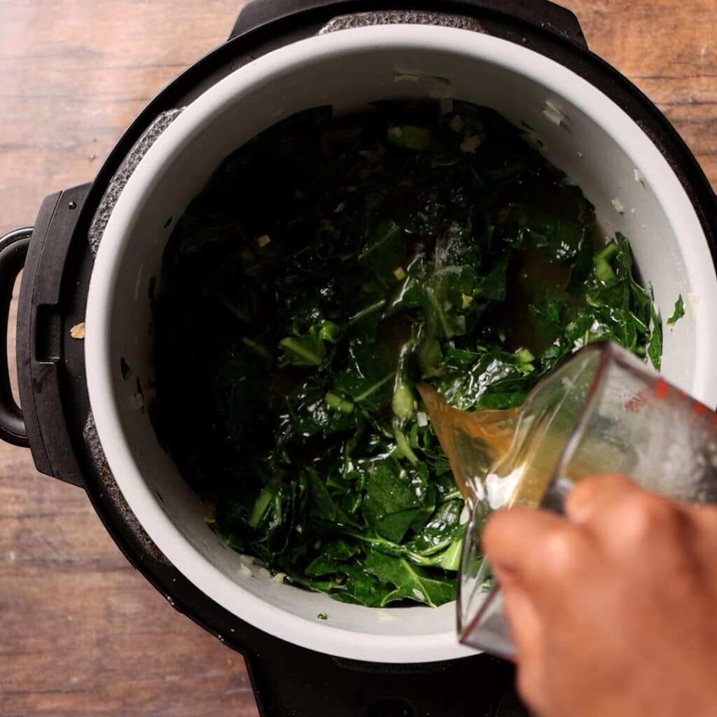 broth being add to greens in an instant pot