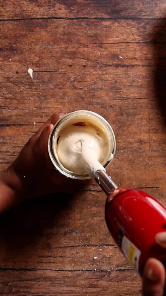 top angle of tofu being blended with immersion blender