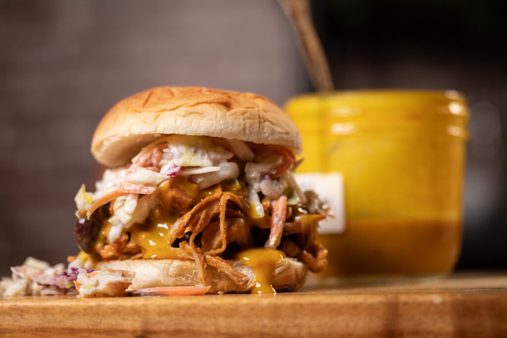 mustard BBQ sauce on vegan pulled pork sandwich