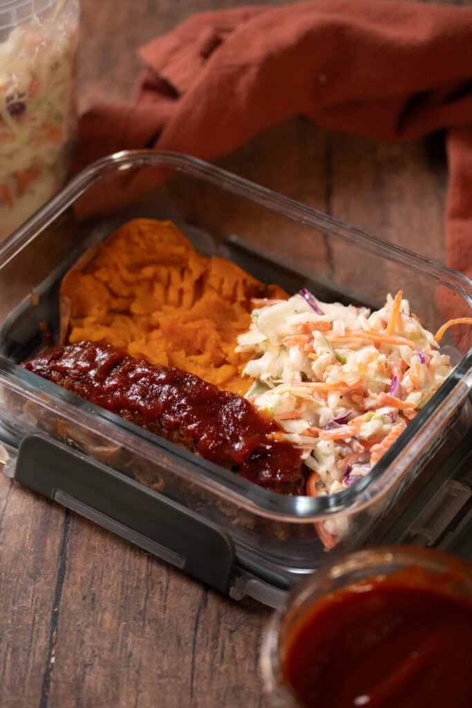 vegan ribs in meal prep container with baked sweet potato and coleslaw