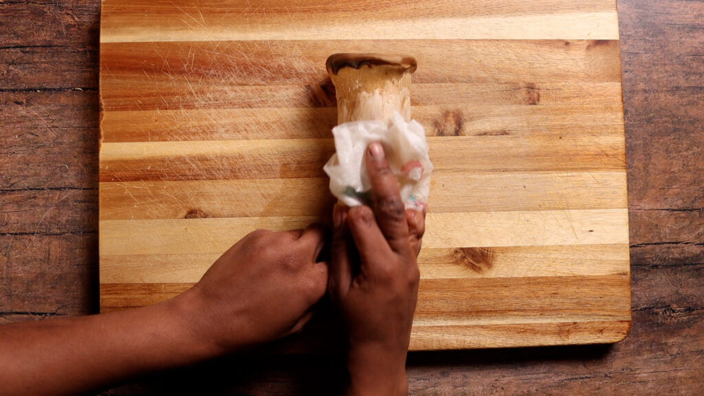 wiping down king oyster mushroom