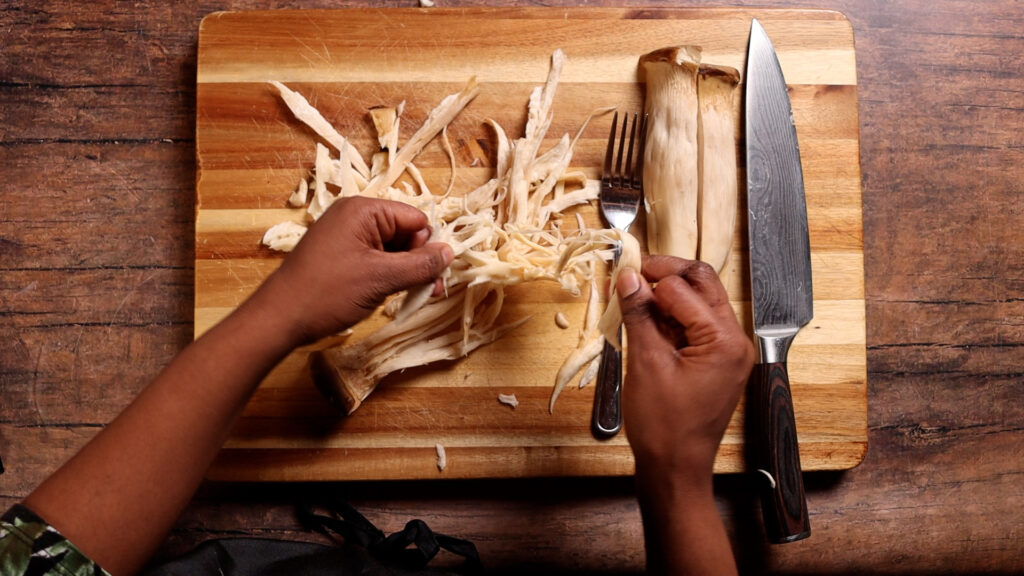 shredding a king oyster mushroom