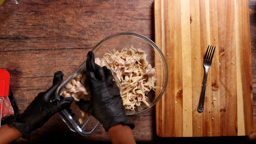 adding jackfruit and oyster mushrooms to a mixing bowl